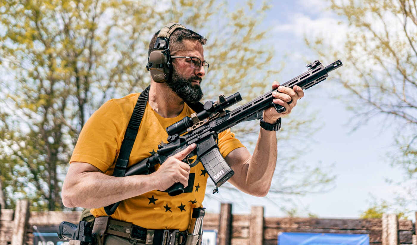 Man holding SAINT rifle with Trijicon Credo HX rifle scope