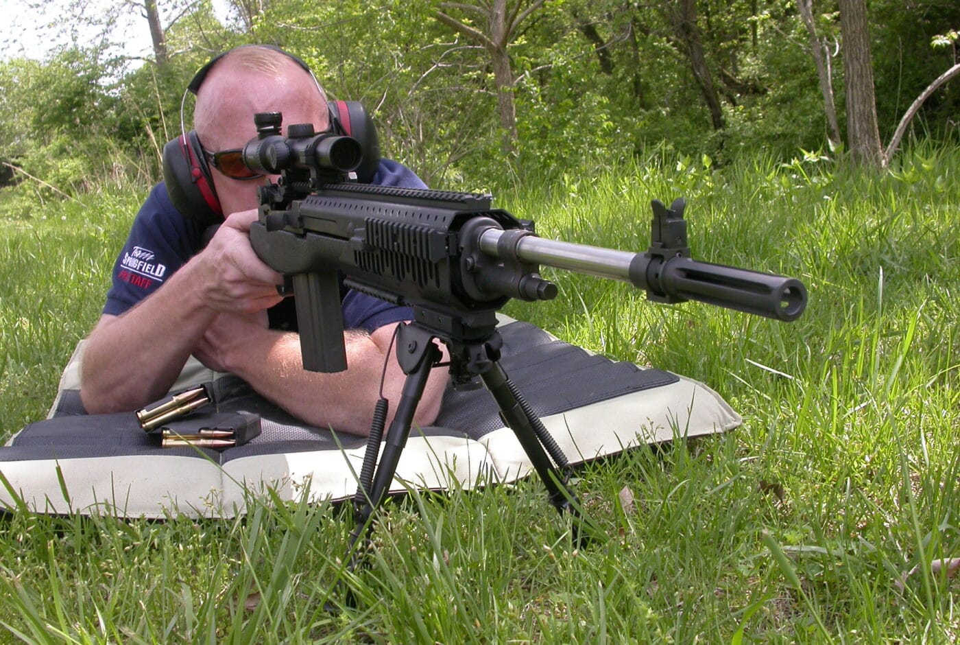 Man shooting a rifle from a prone position with bipod