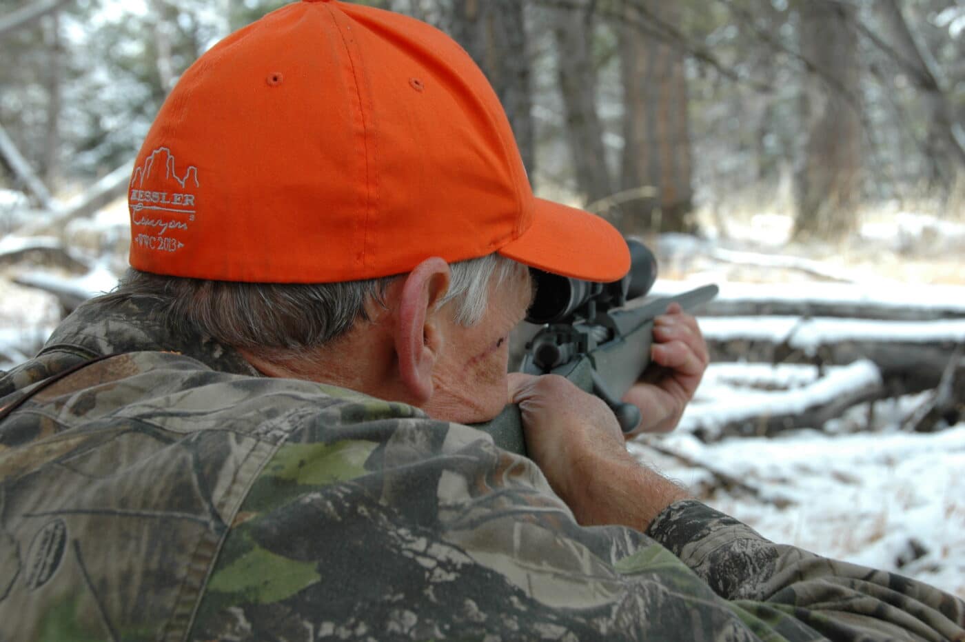 Man using a rifle scope for deer hunting