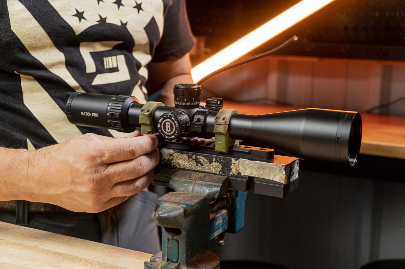 Man using a vice block to level a scope