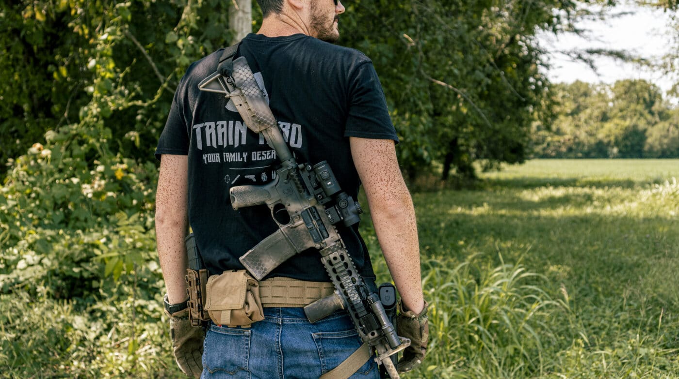 Man carrying a rifle on the back with a two-point sling