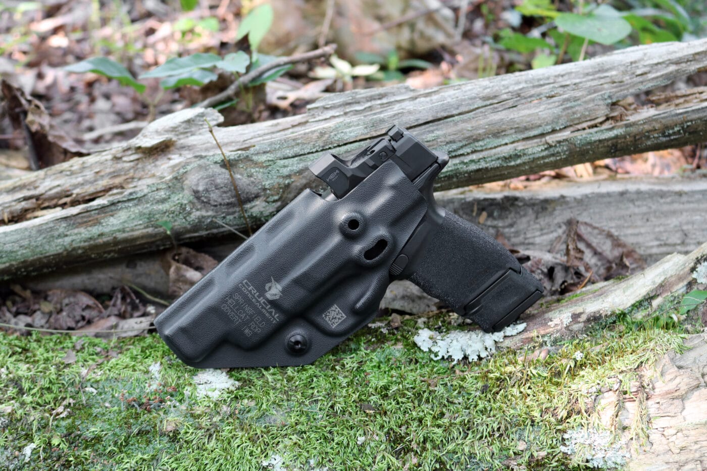 Hellcat pistol in Crucial Concealment Covert holster on moss and wood