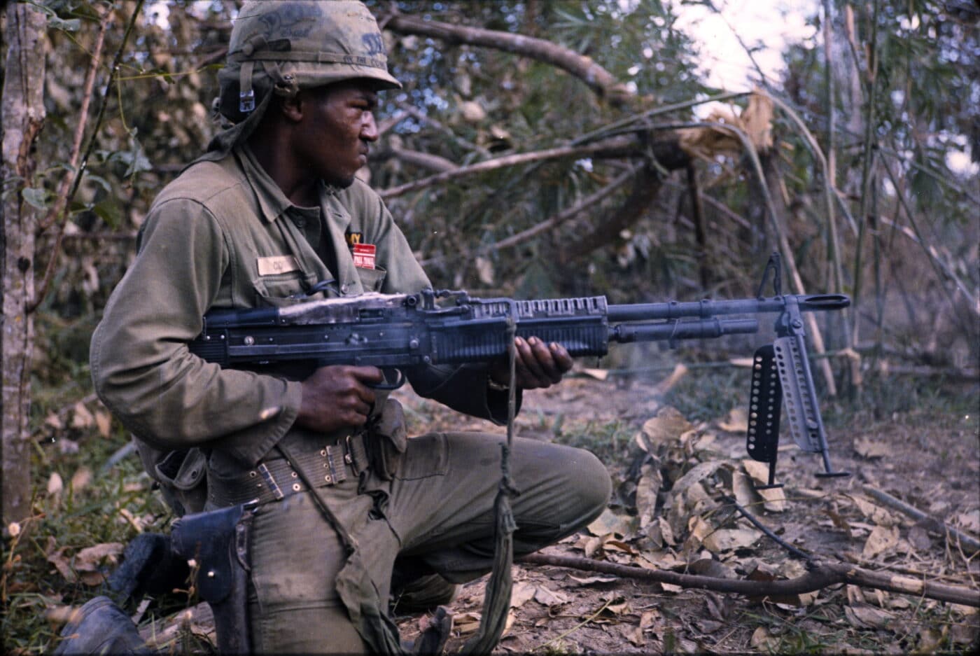 African American army soldier firing M60 in Viet Nam War near Cu Chi