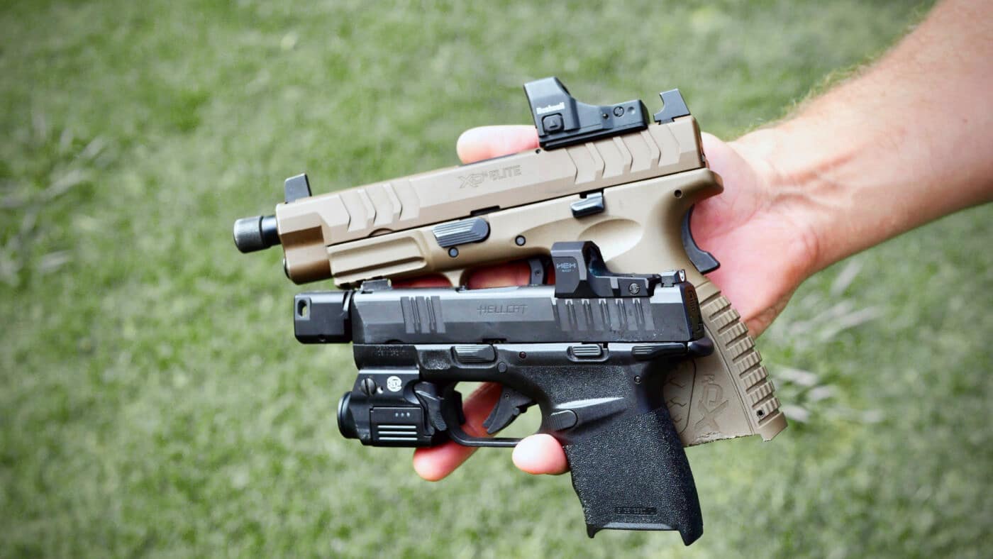 Man holding Hellcat pistol and XD-M Elite pistol in one hand to show size difference