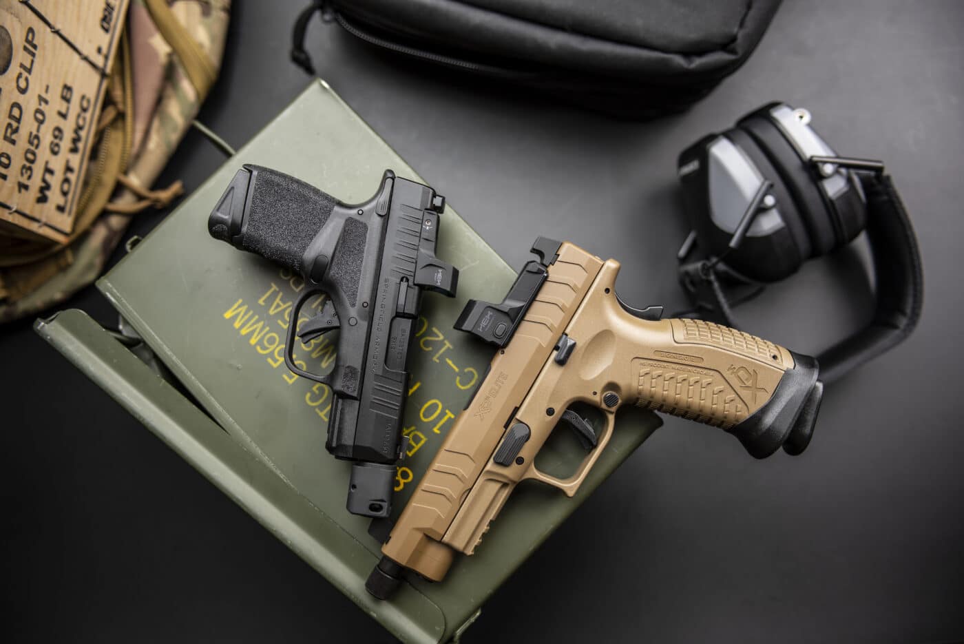 Springfield Armory Hellcat and XD-M Elite polymer pistols on top of ammo box