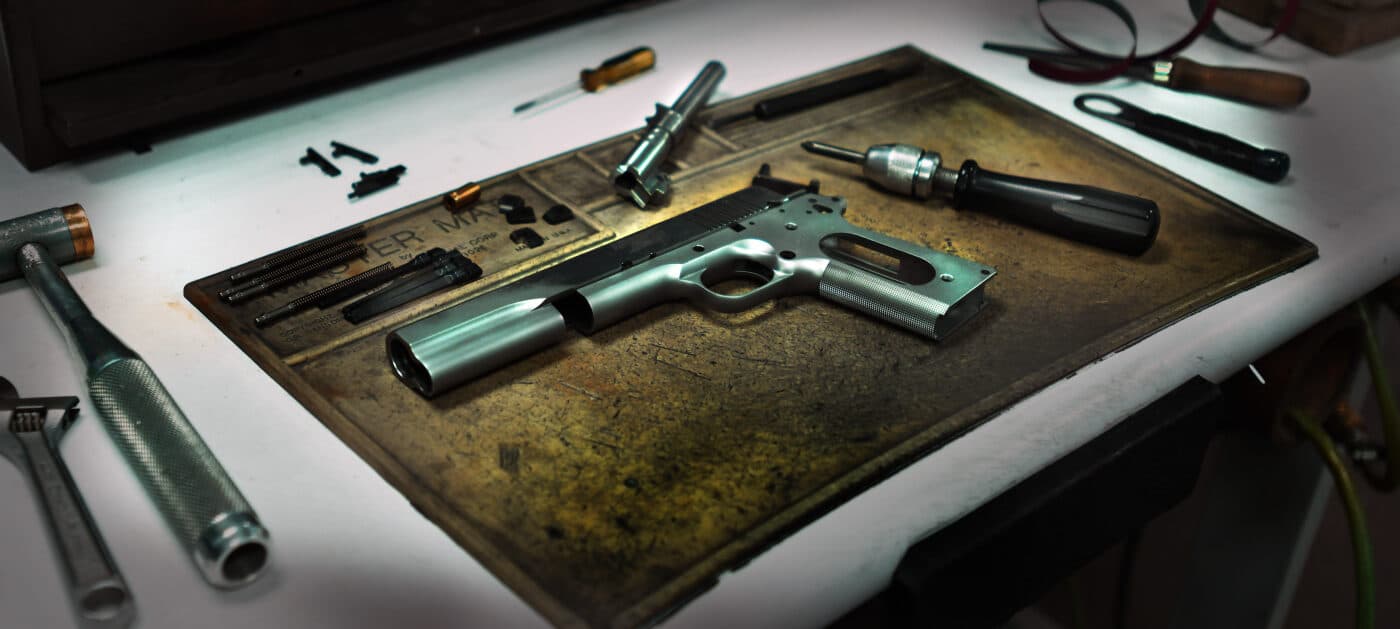 Springfield 1911 pistol disassembled on workbench