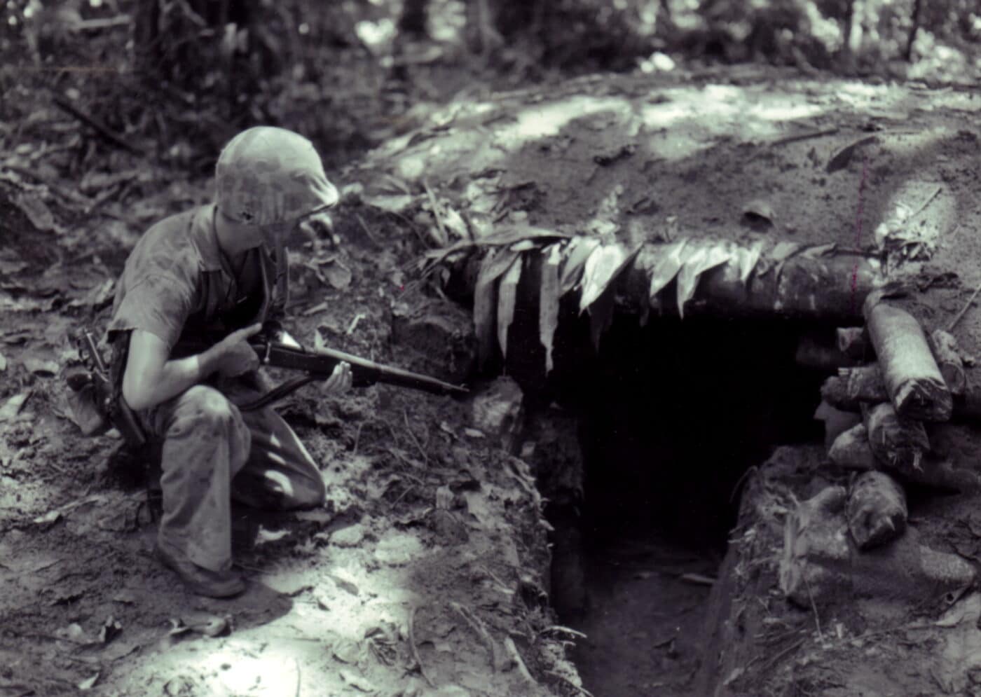 A U.S. Marine examines a Japanese bunker on Bougainville Island in 1944 while holding an M1903A3 rifle