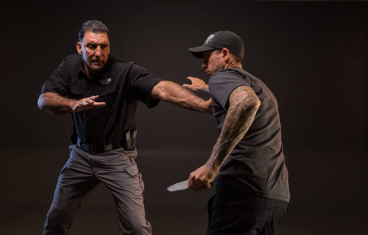 Two men practicing defensive knife fighting