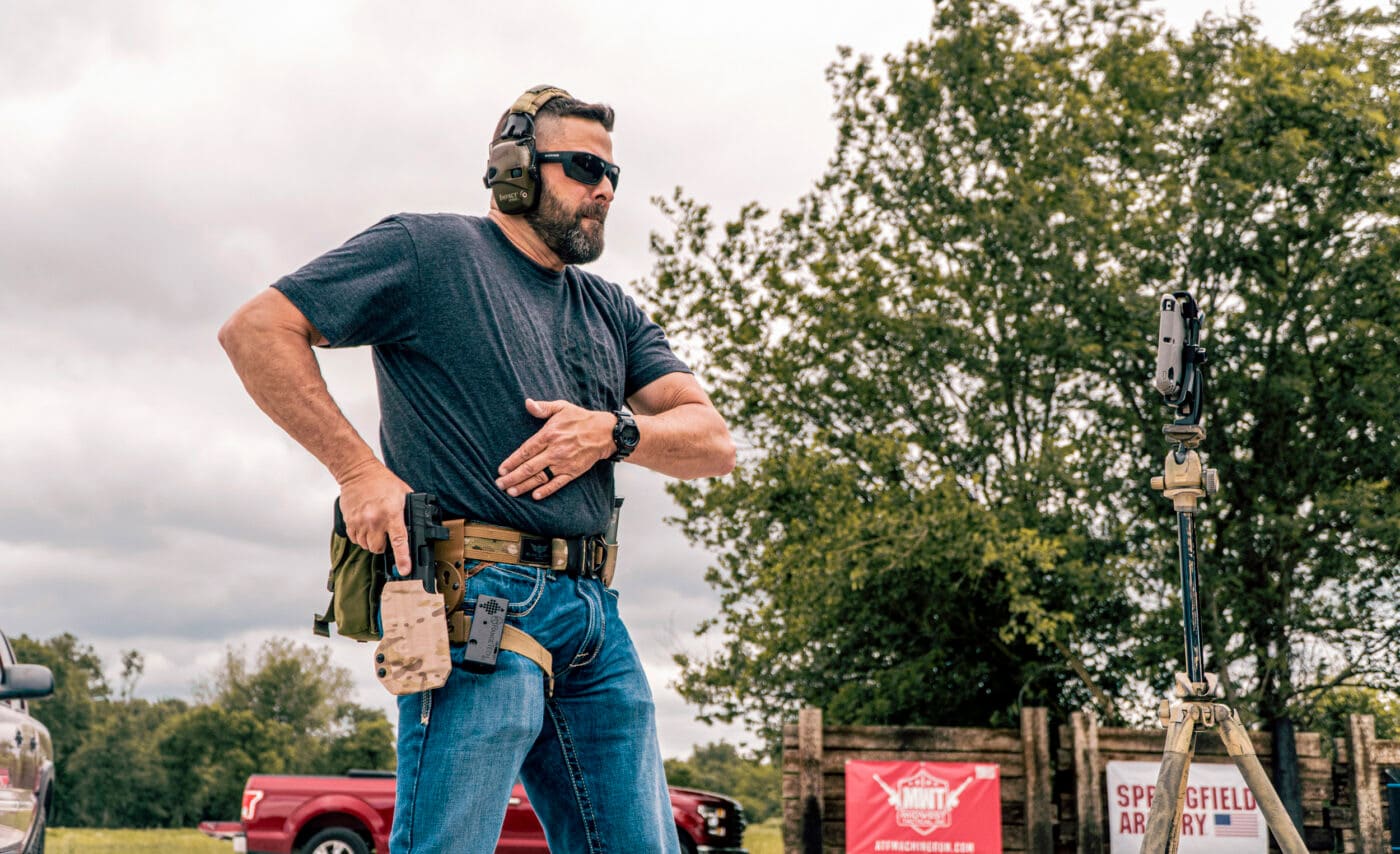 Man drawing pistol from holster on a battle belt