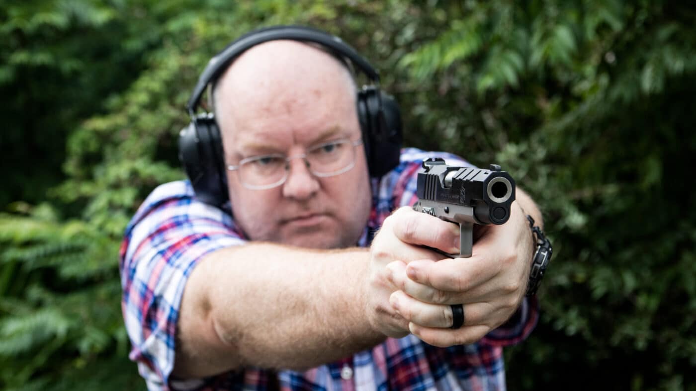 Homem atirando no Emissário no campo