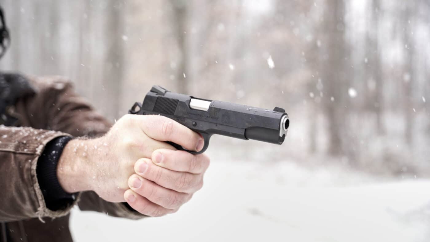 Man holding Springfield Armory Garrison 1911 pistol at the range