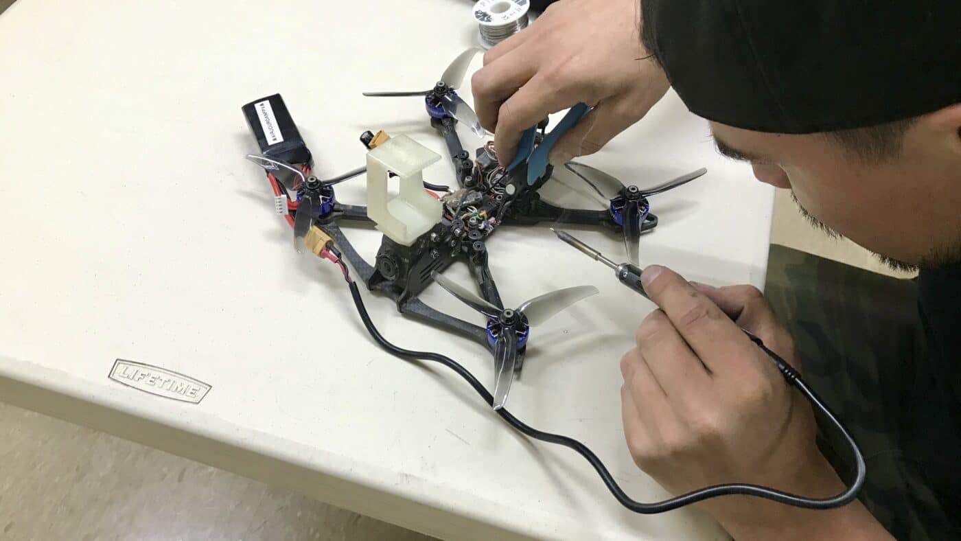 Drone pilot at work soldering a drone