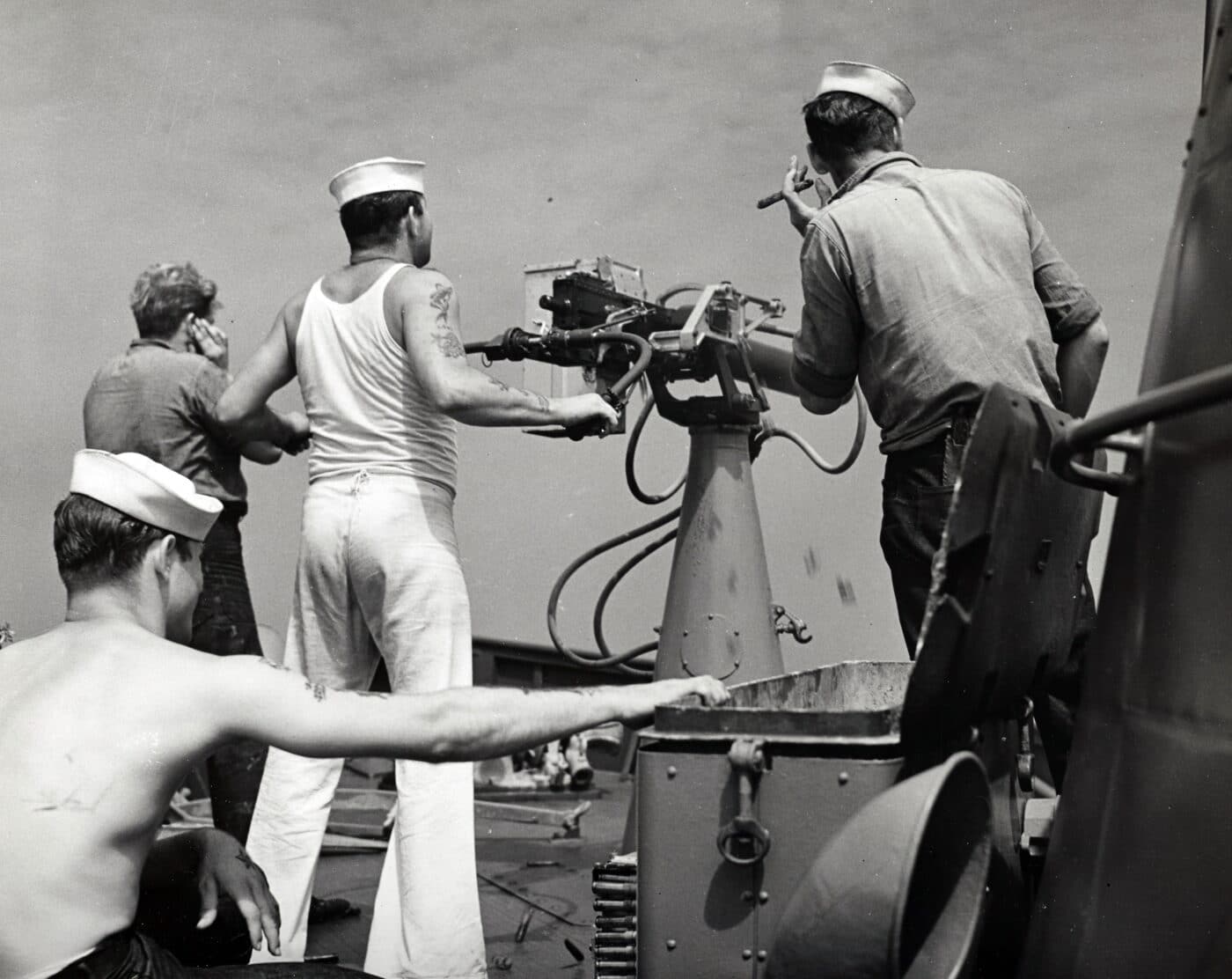 Sailor firing .50 caliber machine gun on US ship