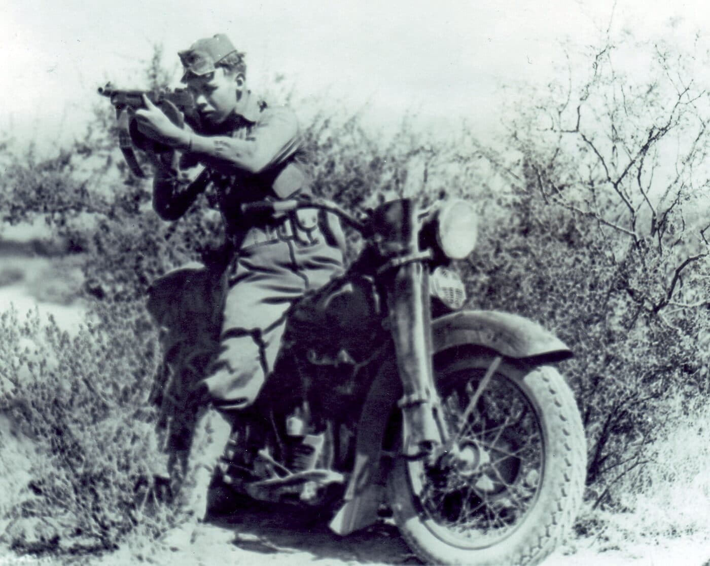 Solider using a Thompson SMG while on motorcycle