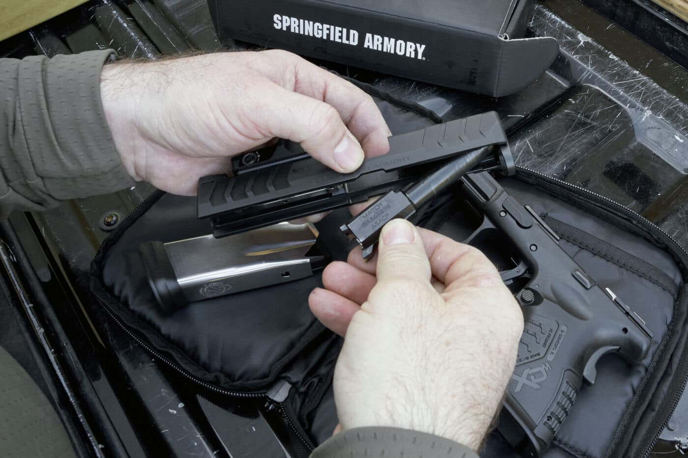 Man field stripping an XD-M Elite 3.8" Compact OSP .45 ACP pistol