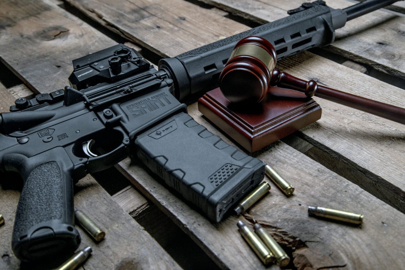 AR rifle next to ammo and gavel