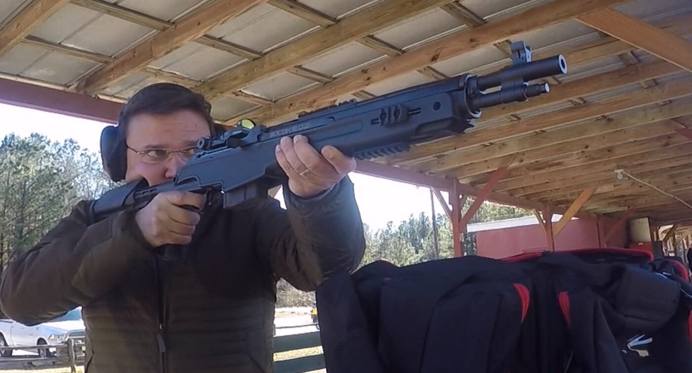 Man shooting M1A rifle with aftermarket stock