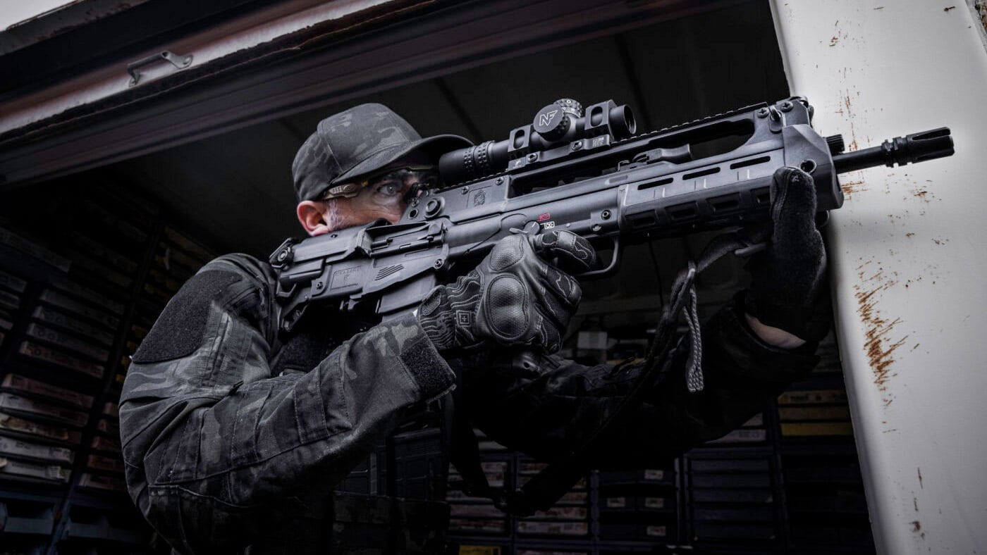 Man demonstrating adjustable stock on Hellion bullpup rifle