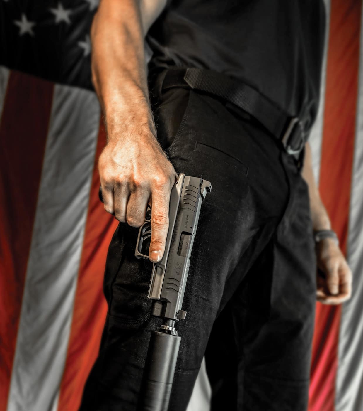 Man holding Springfield Armory pistol with a suppressor