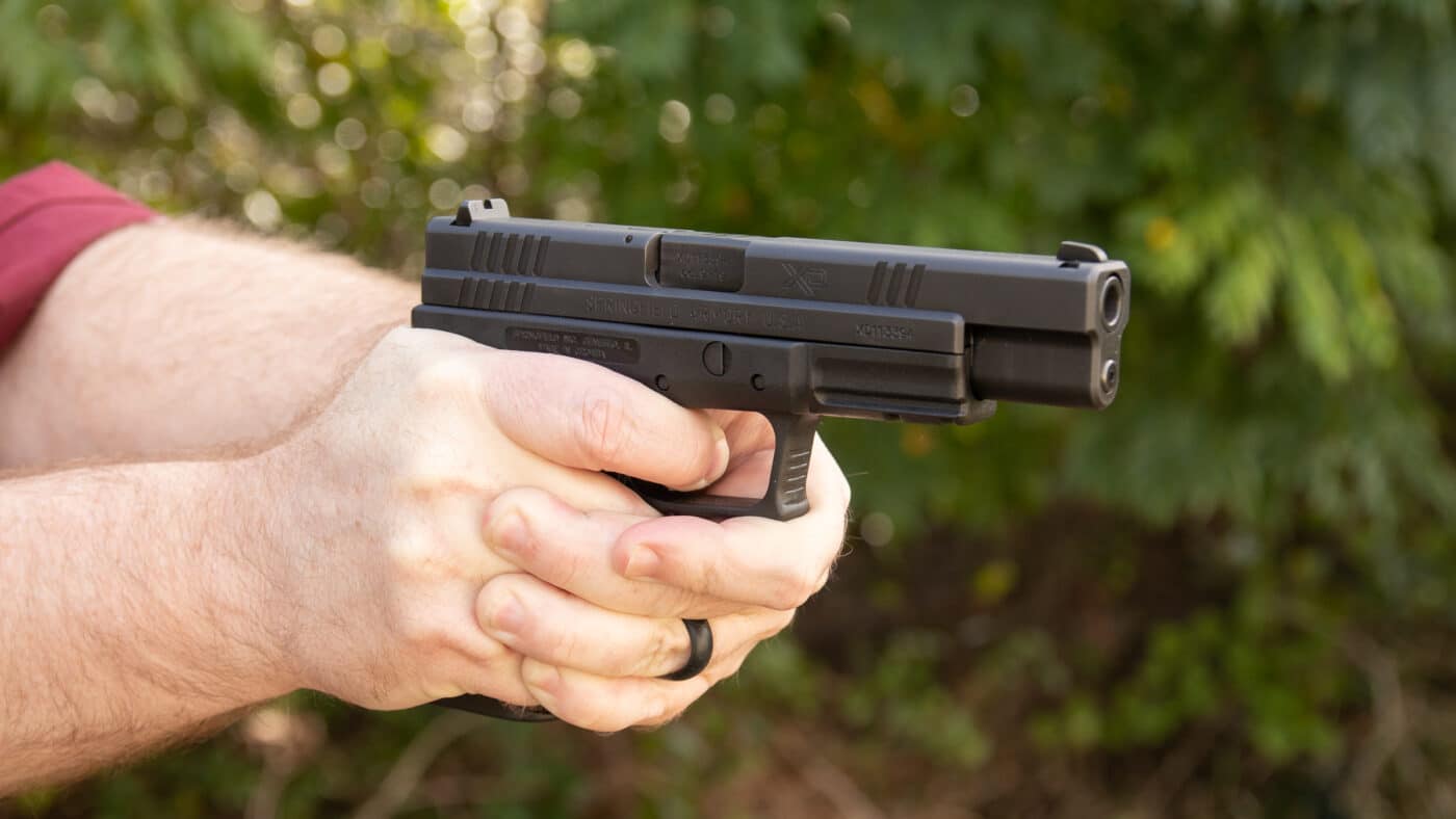 Man holding Springfield XD Tactical Model pistol in 9mm