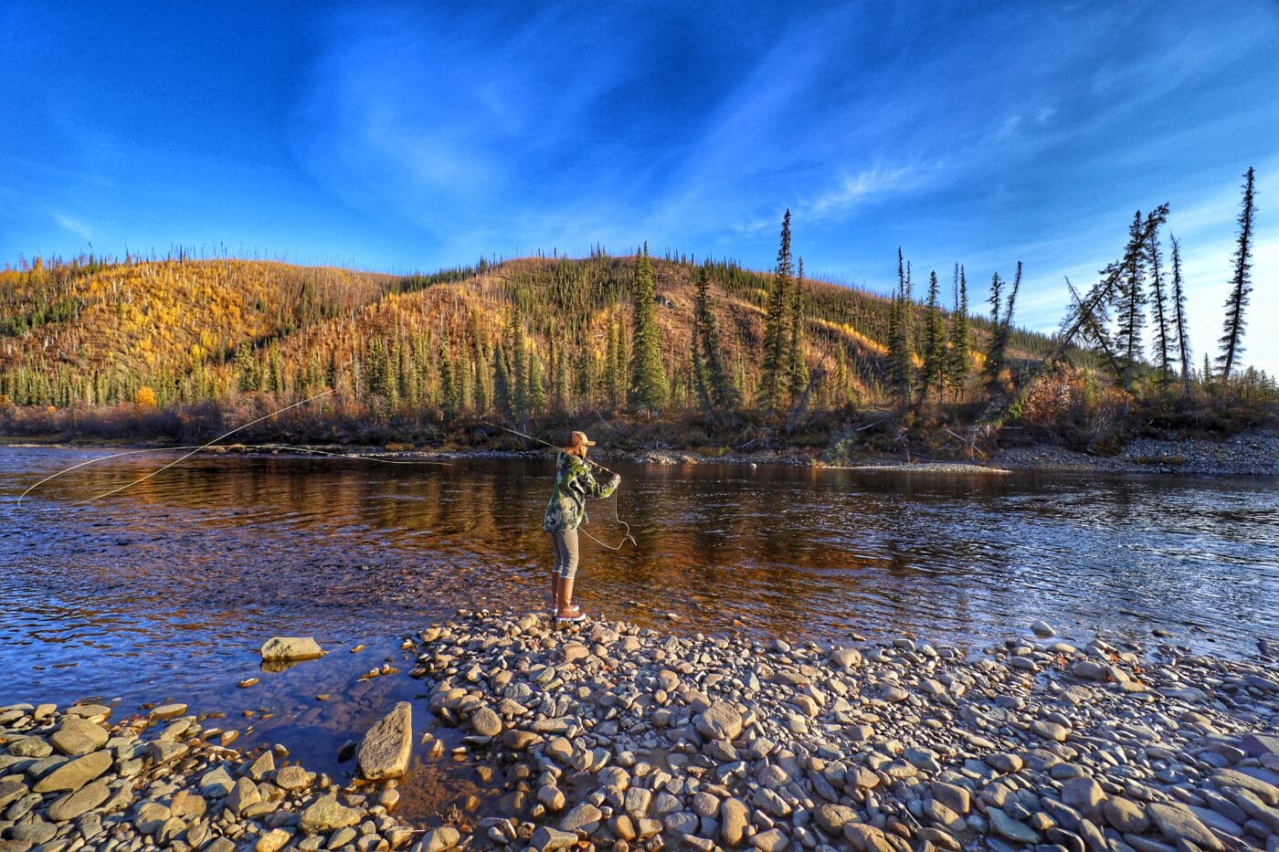 Woman fly fishing in Alaska