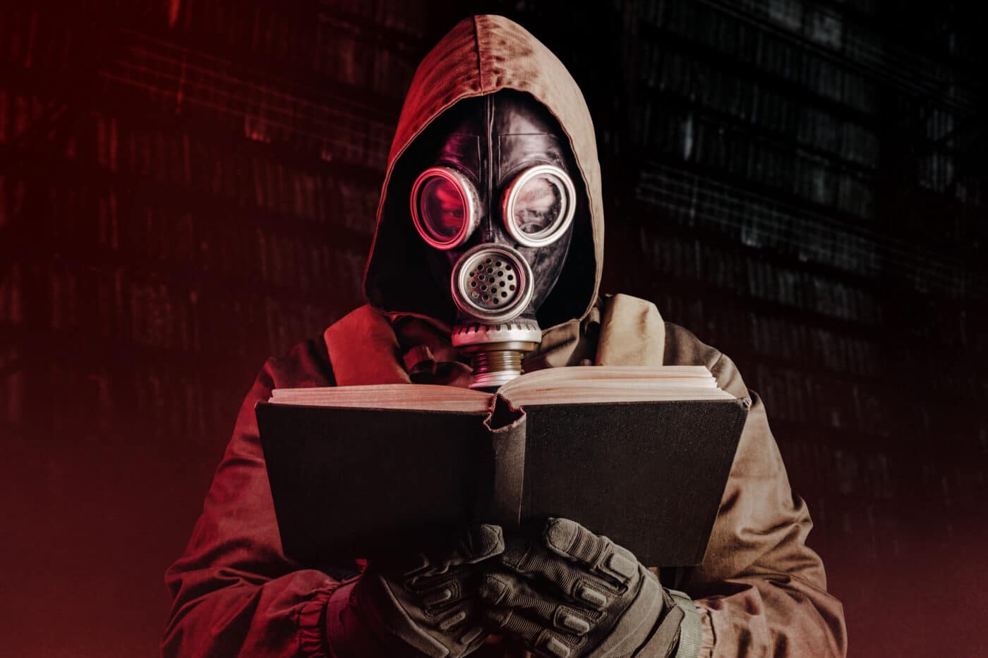Man in gas mask reading survival book