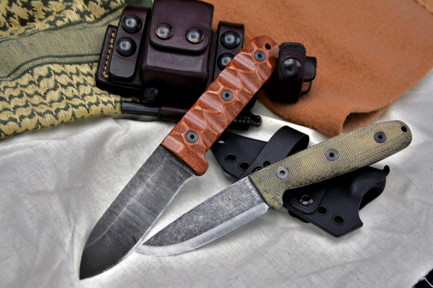 ESEE knives on a table next to sheaths