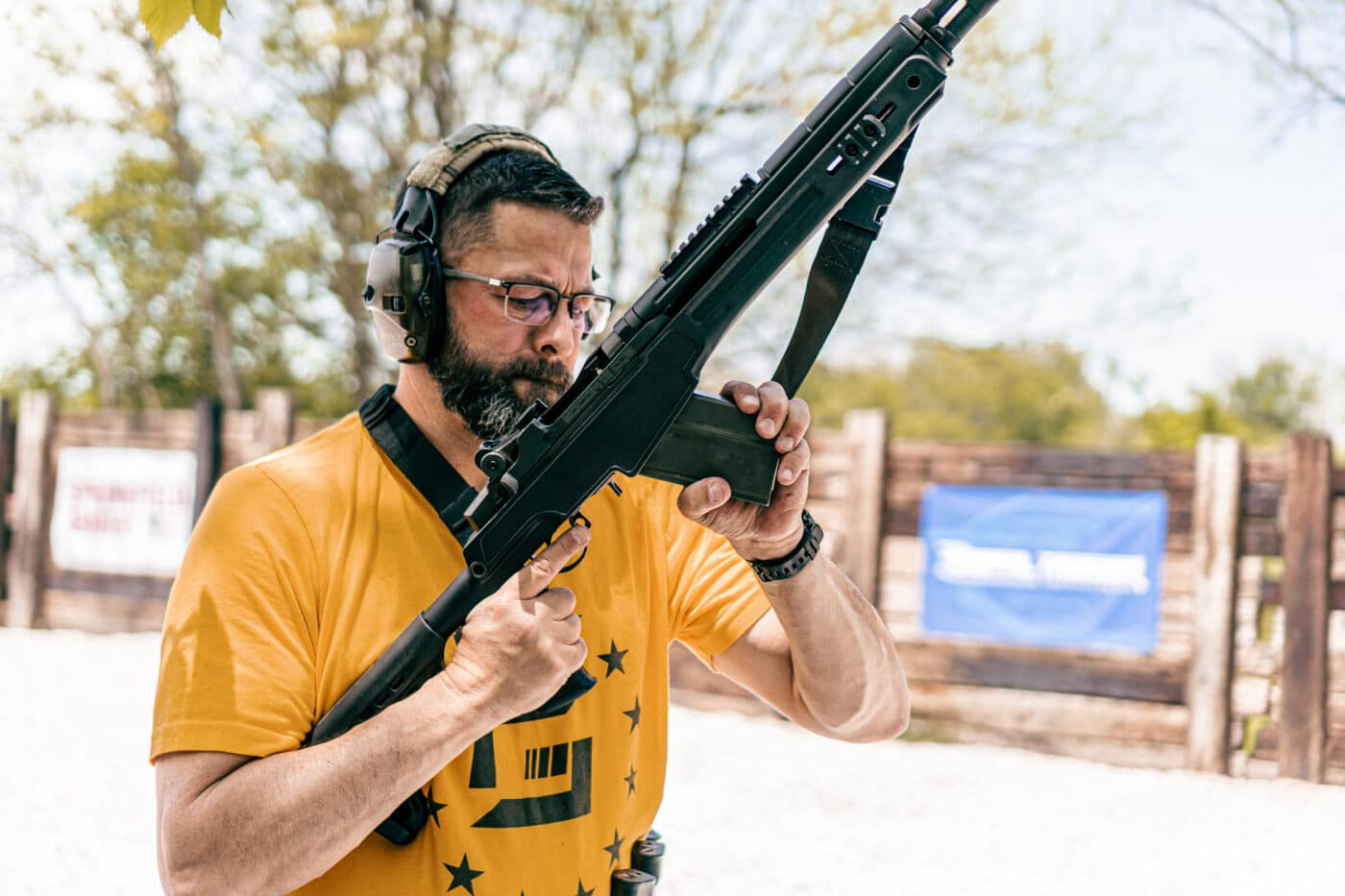 Man reloading an AR-15 rifle with a sling attached