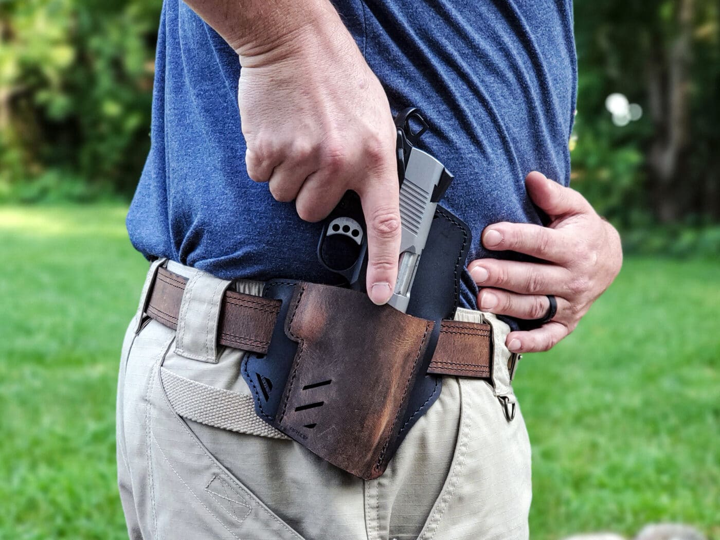 Man drawing a 1911 EMP from the Rough Rider holster