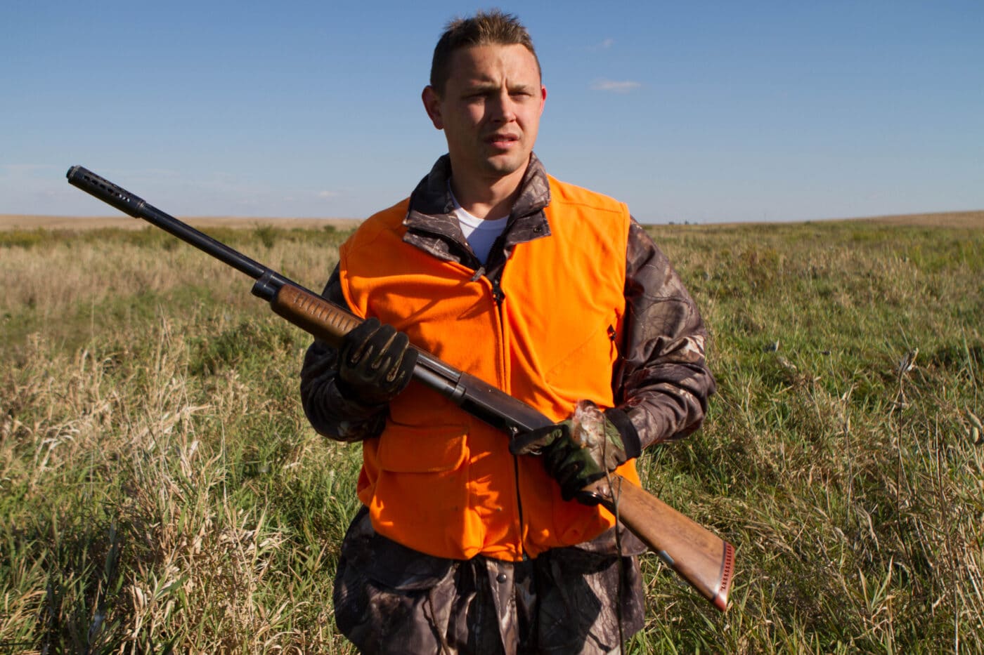 Sen. Neil Anderson with Sears & Roebuck 12 gauge shotgun in a field