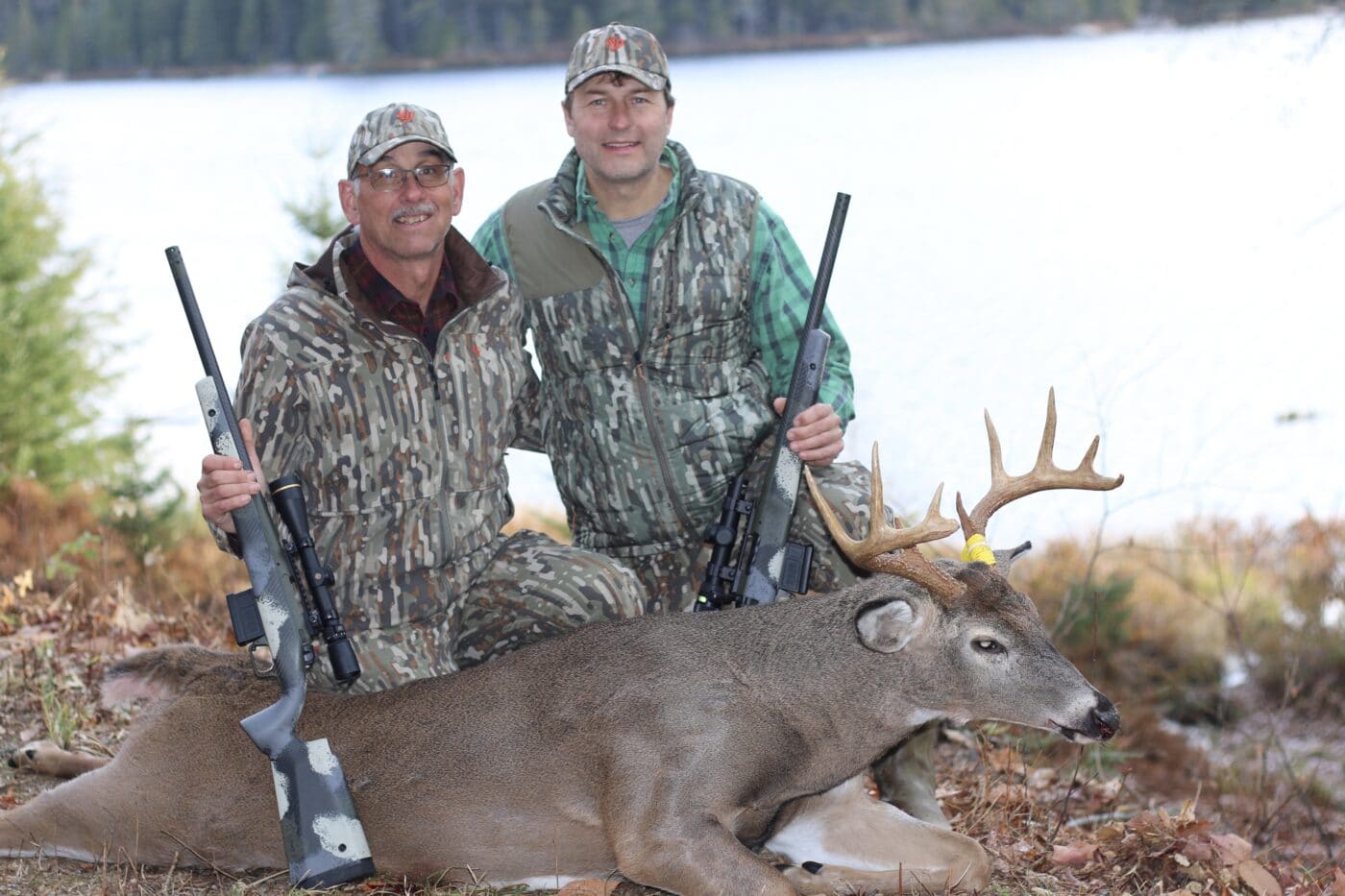 Two deer hunters with buck