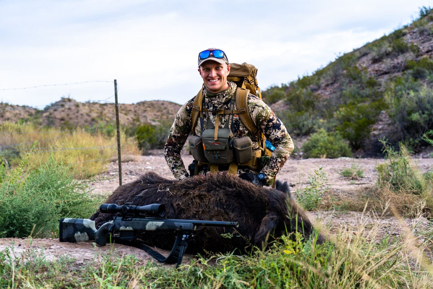 Man hog hunting in Texas with dead boar and rifle