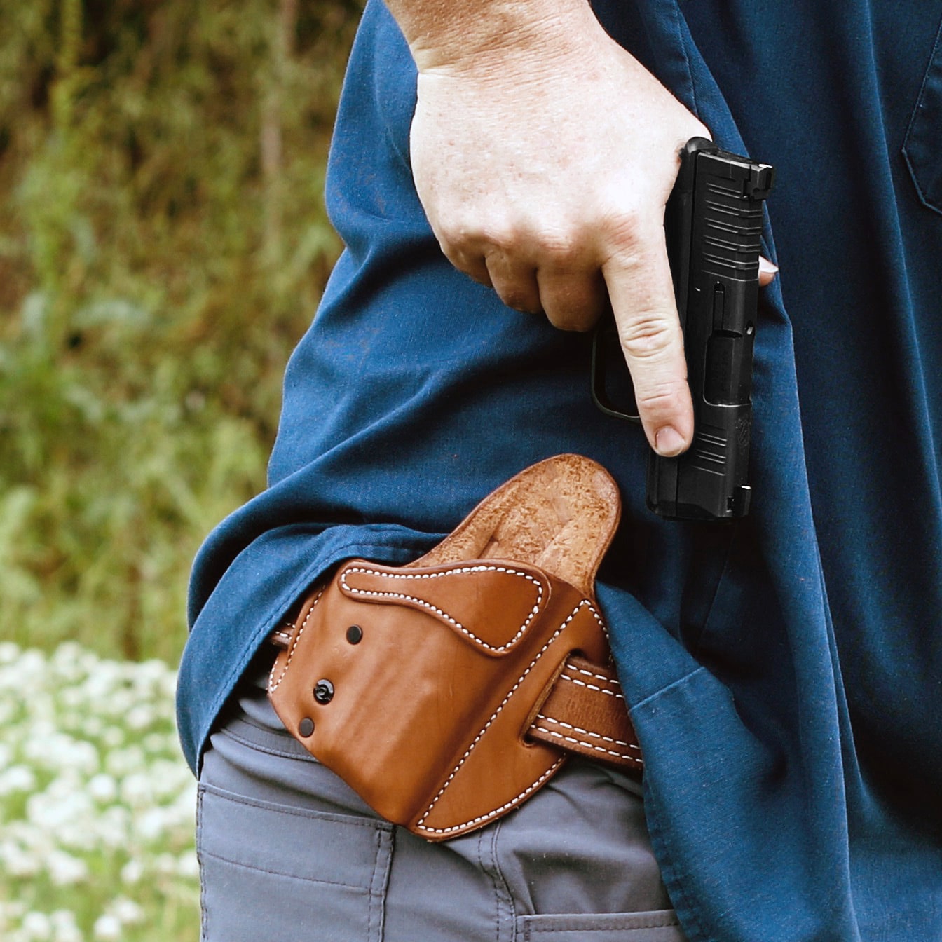 Man holding pistol while using an Urban Carry concealment holster