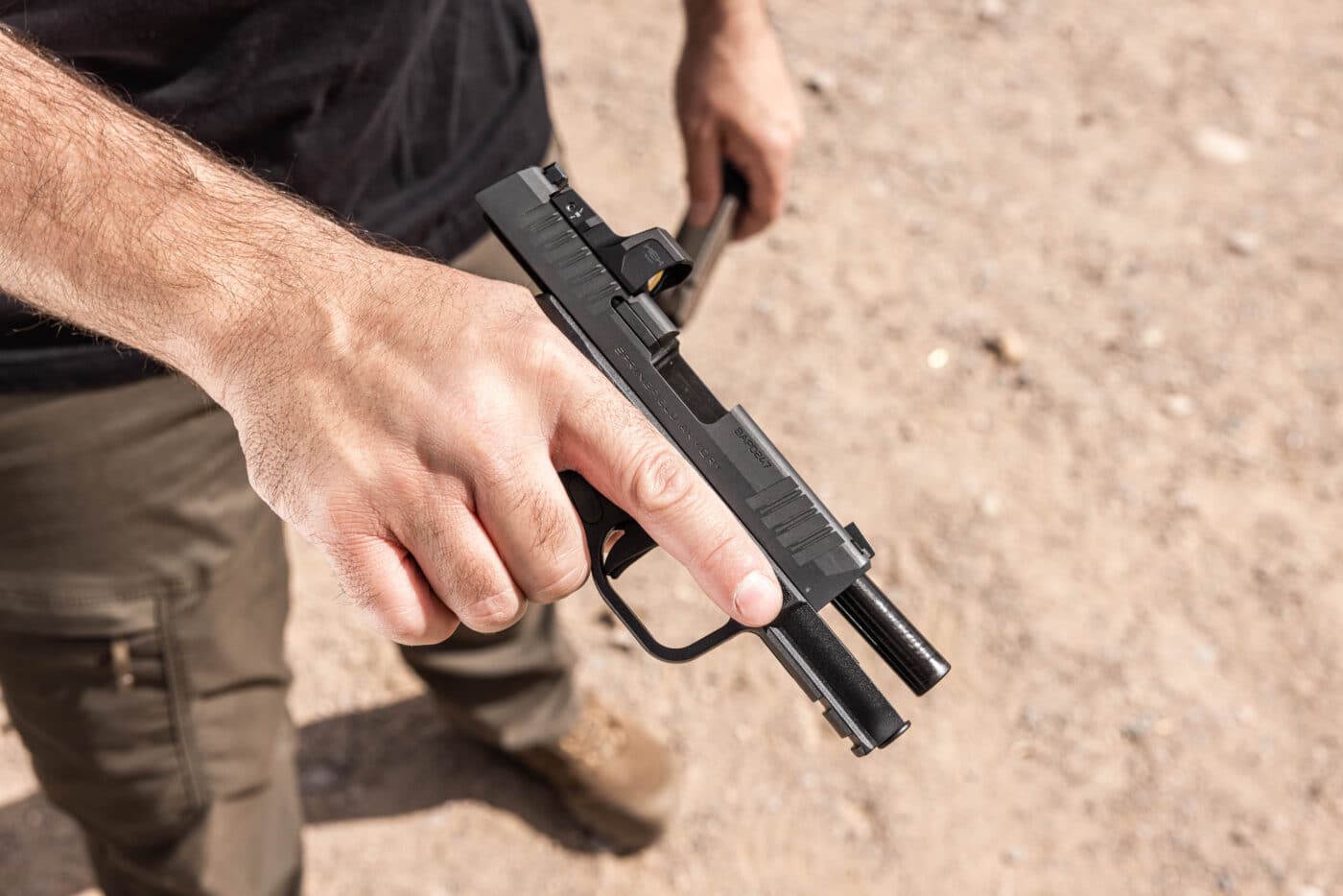 Man holding Springfield Armory Hellcat Pro pistol with slide locked back