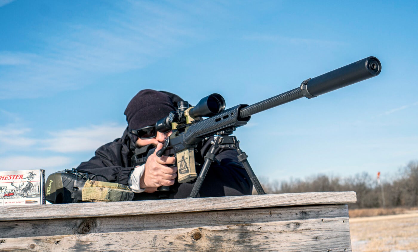 Man at a firing range testing Surefire SOCOM65-Ti silencer on Springfield Waypoint rifle