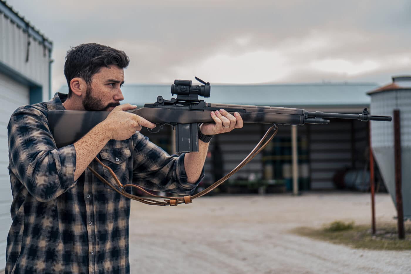 Man aiming M1A rifle with ARMS #18 scope mount