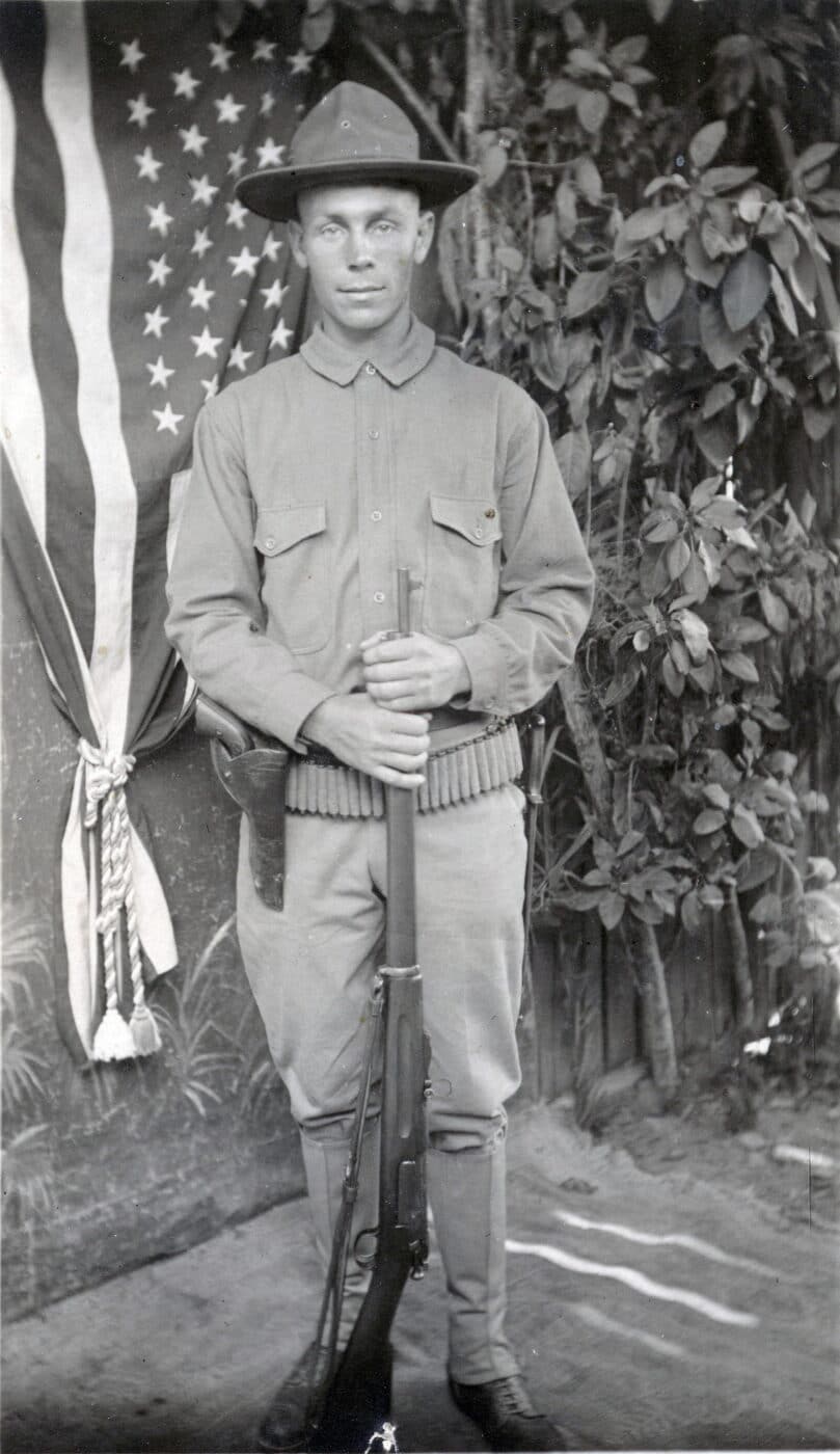 Soldier posting with Krag-Jorg rifle in a photography studio