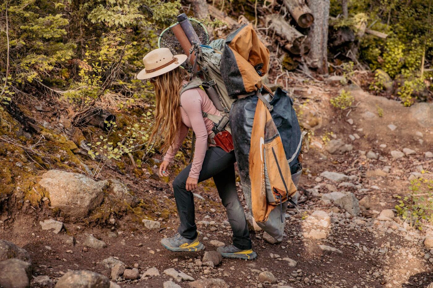 Woman backpacking while carrying 1911 pistol in holster