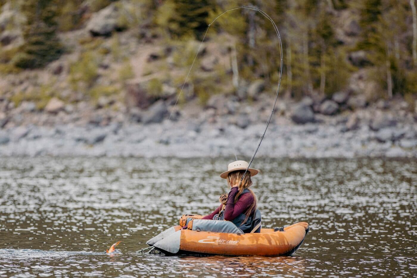 Woman fly fishing while carrying a 1911 pistol for bear protection