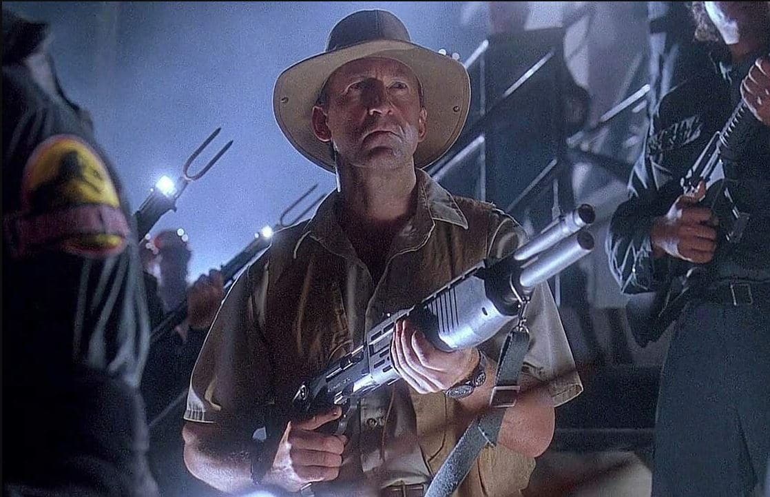 Actor Bob Peck holding a shotgun in Jurassic Park