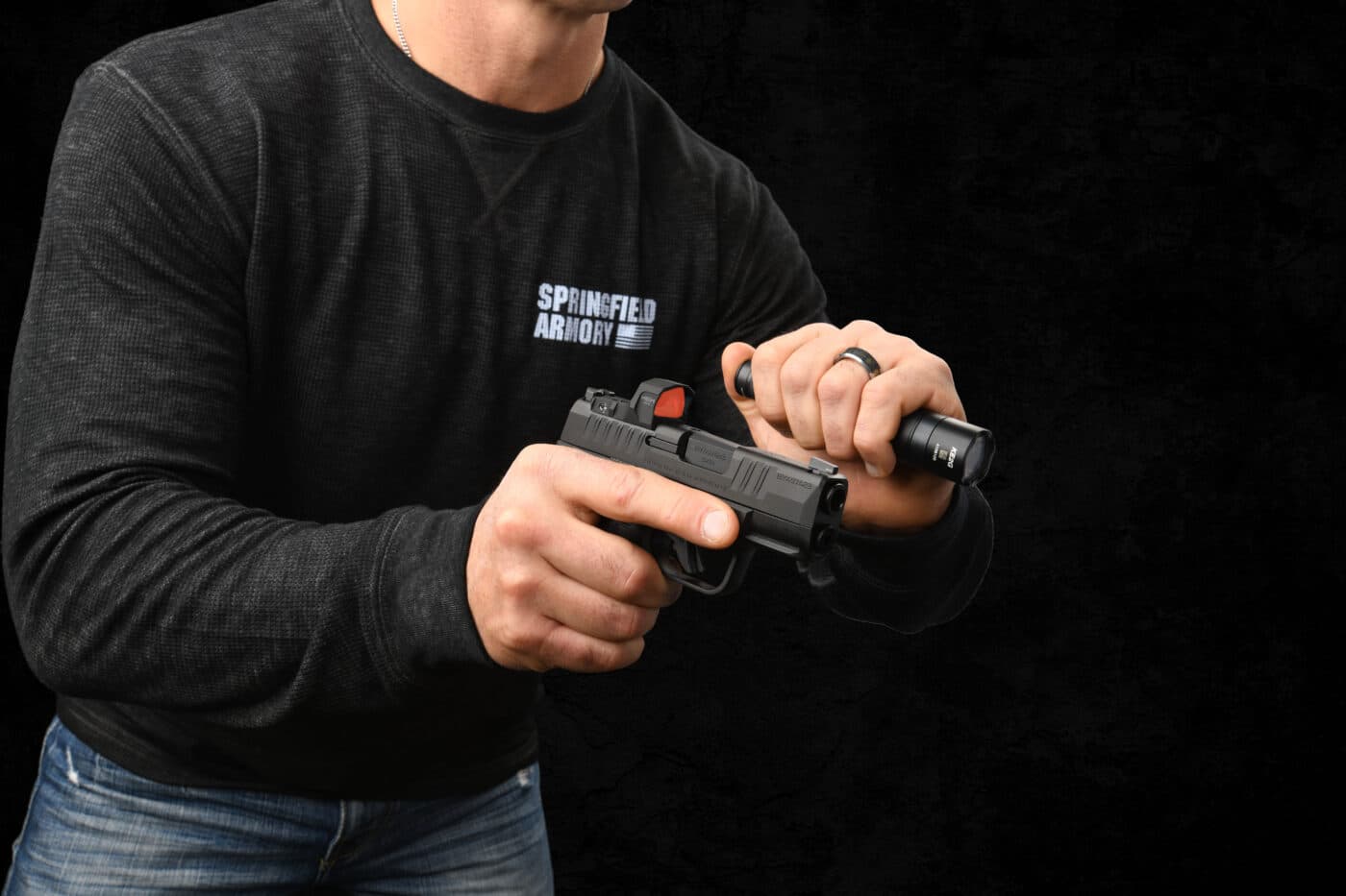 Man demonstrating basic technique of carrying pistol and separate handheld tactical light