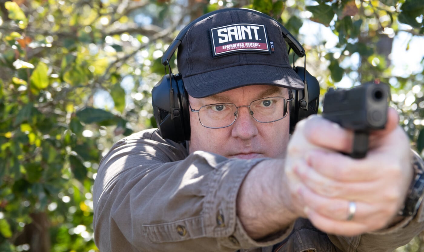 Man demonstrating proper way to wear hearing protection while shooting