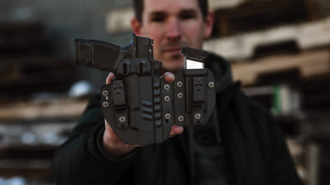 Man holding CrossBreed Rogue System holster