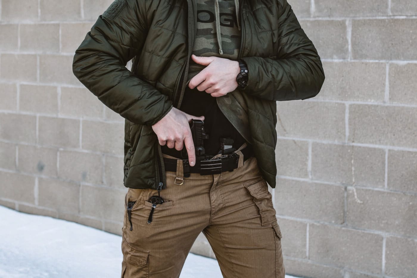 Man holstering pistol in CrossBreed Rogue System holster during evaluation test