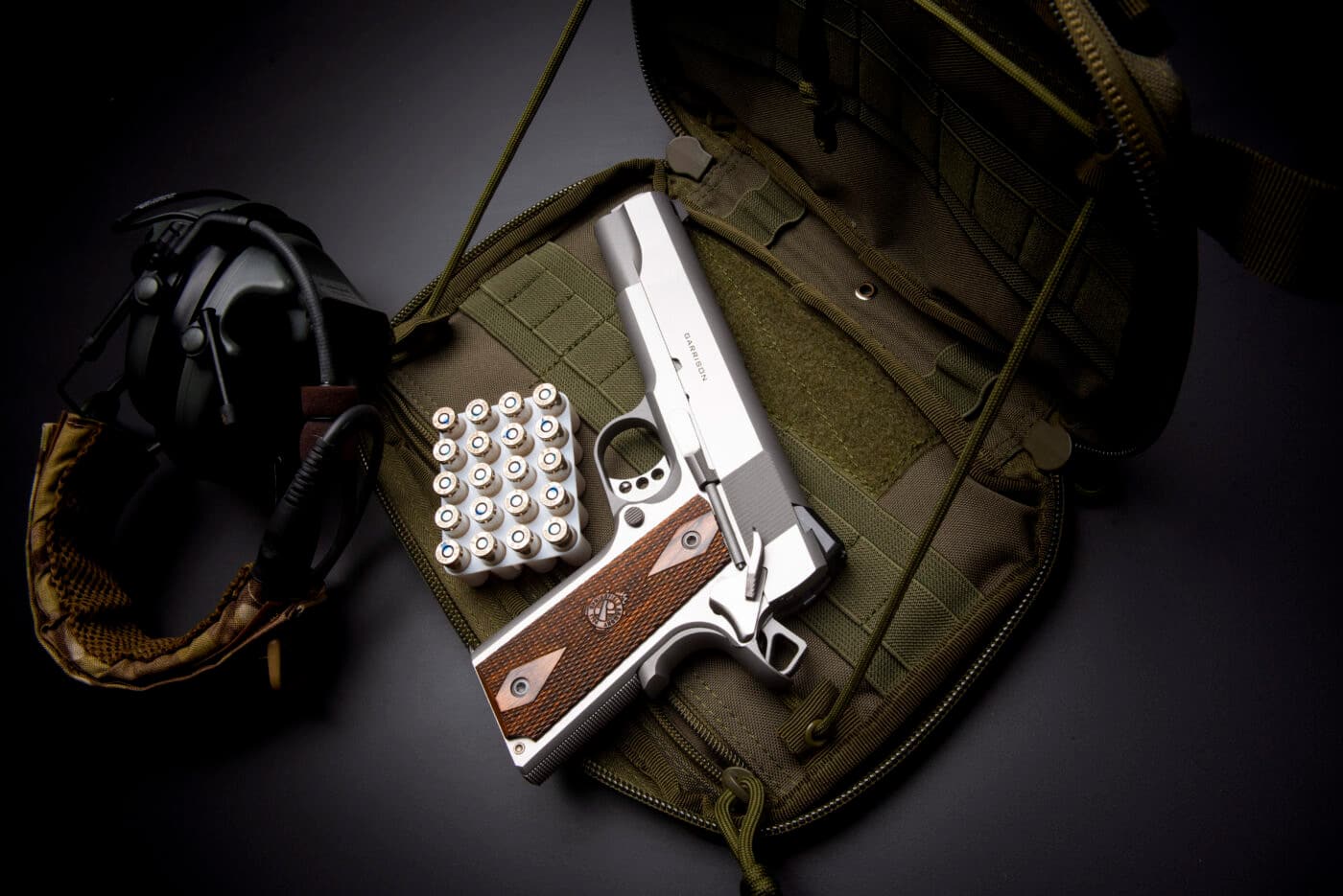 Springfield Armory 9mm Garrison 1911 in stainless steel next to ammo and range gear