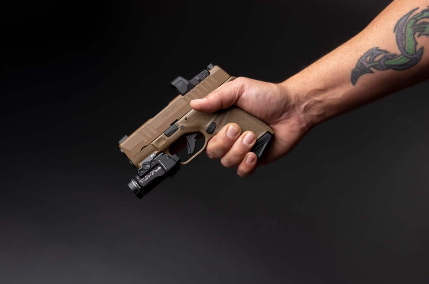Person holding Hellcat FDE pistol with Streamlight TLR-7 Sub attached
