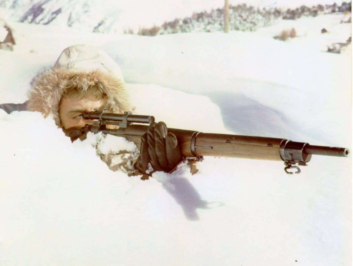 Soldier firing a M1903 sniper rifle in the snow in the French Alps in 1944