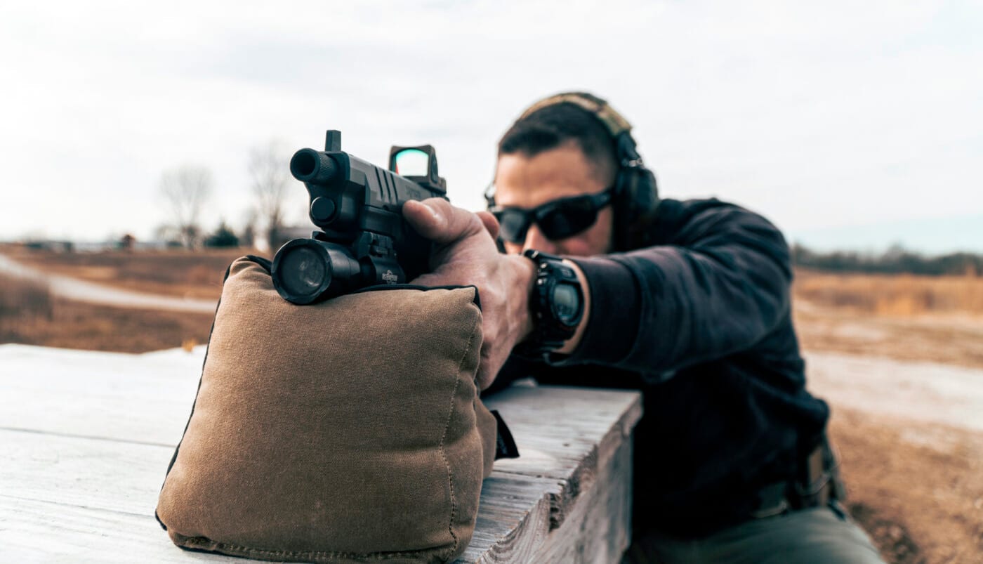 Man testing parallax in a red dot pistol sight