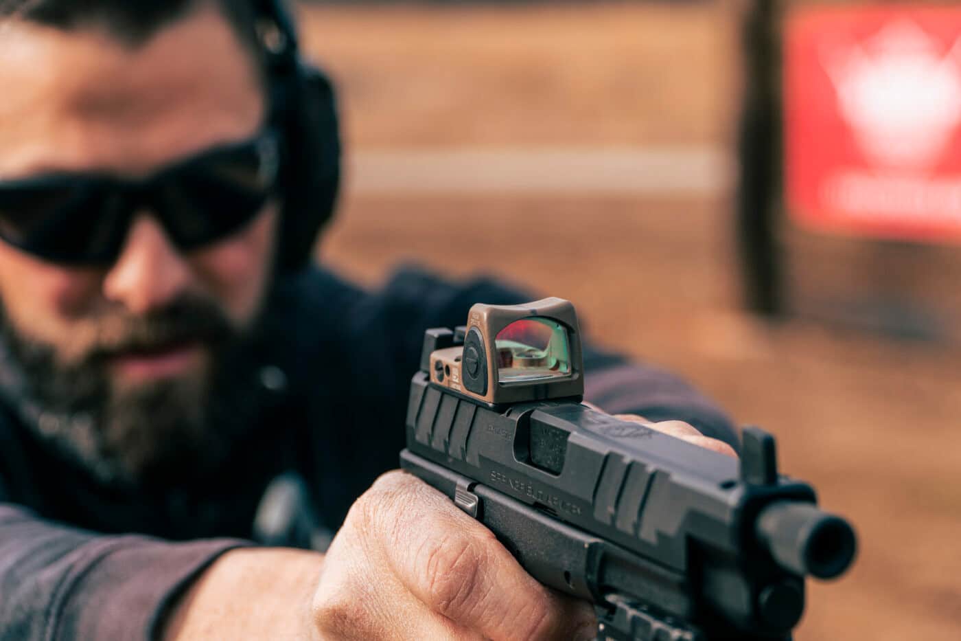 Man testing pistol with red dot sight