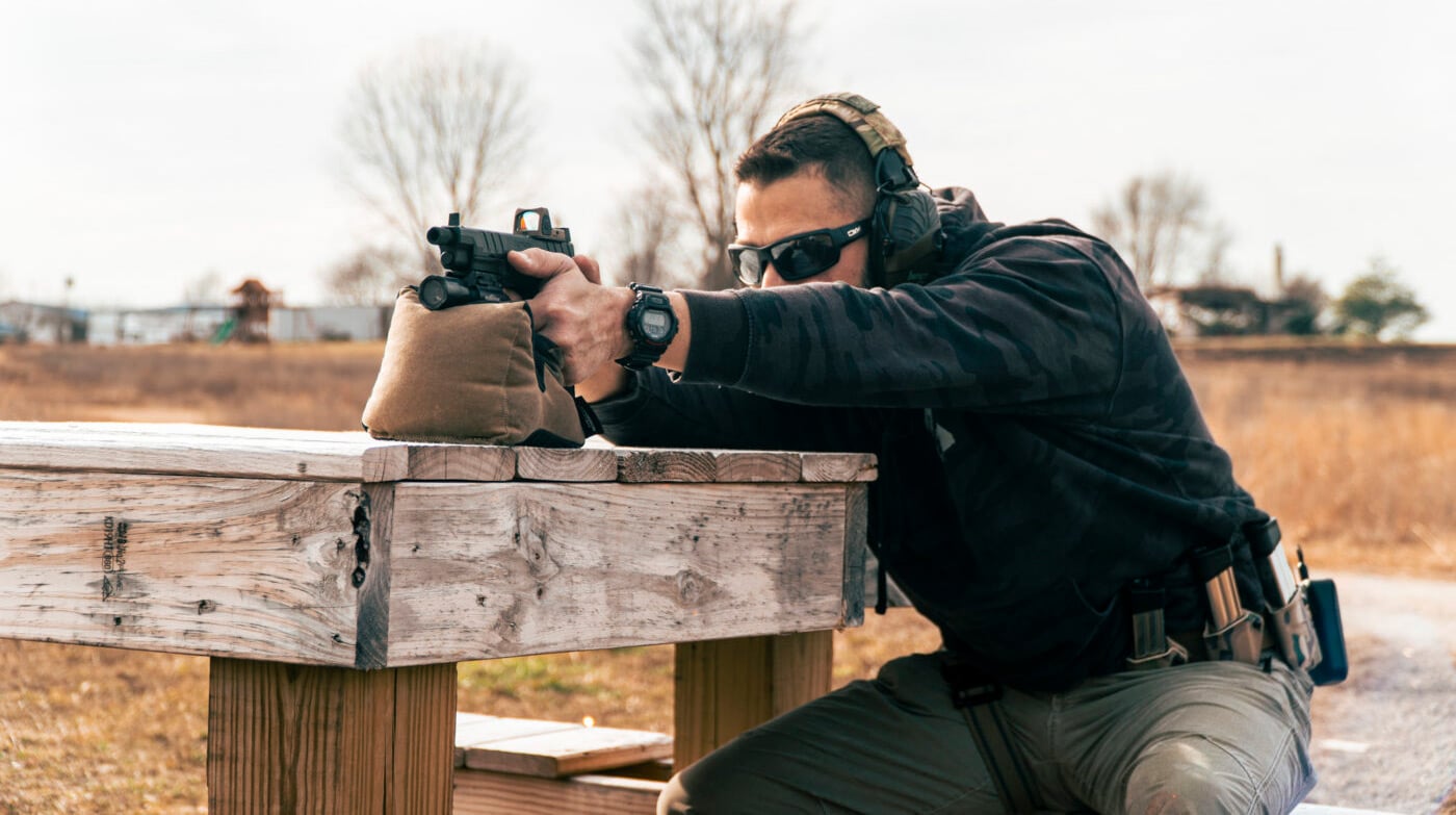 Man testing parallax in a red dot sight mounted to a pistol
